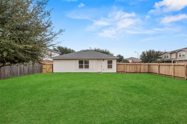 a view of yard with green space and wooden fence