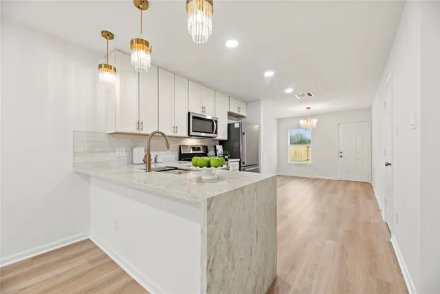 a kitchen with kitchen island granite countertop a sink cabinets and stainless steel appliances