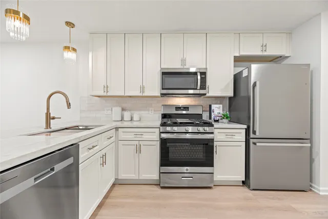 a kitchen with cabinets stainless steel appliances and a counter space