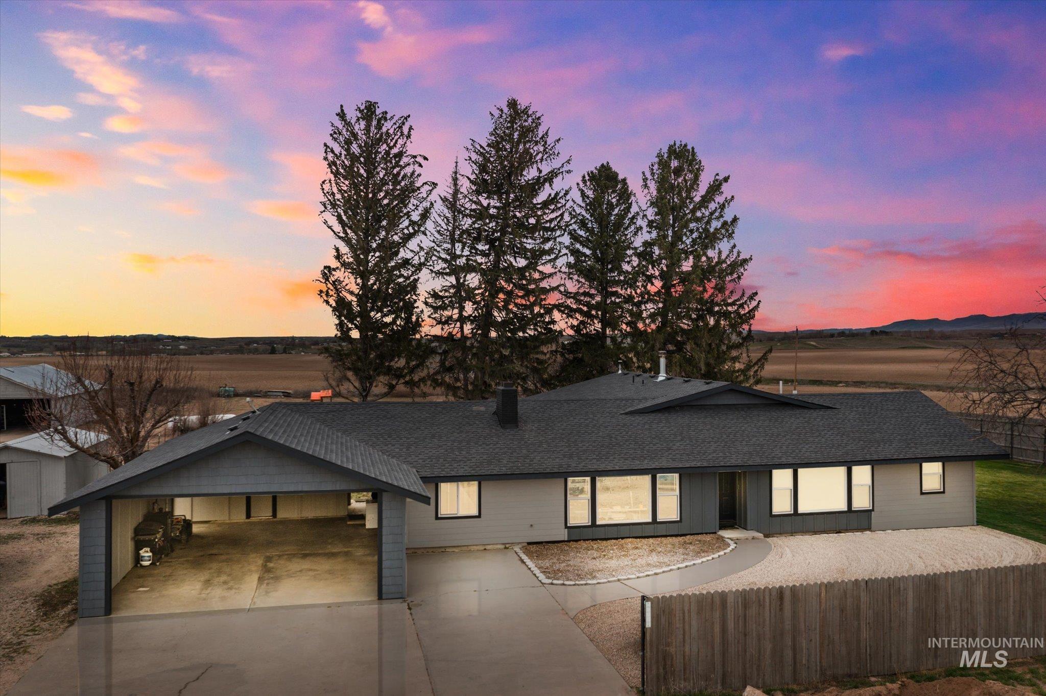 View of front of property featuring roof with shingles and driveway