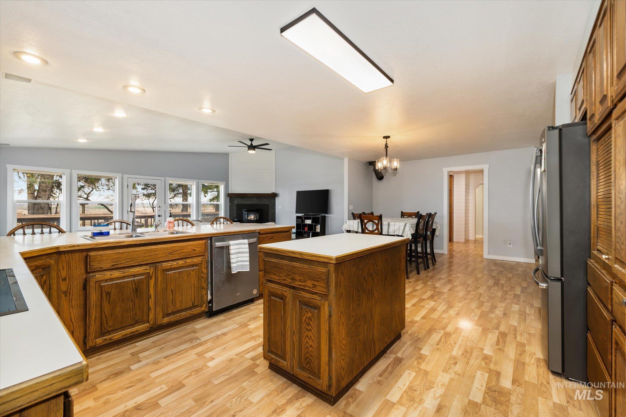15032 Hollow Road Caldwell, ID 83607 - Photo 20 of 50 Kitchen with lofted ceiling, wood finish cabinets, stainless steel appliances, a ceiling fan, and light wood-type flooring