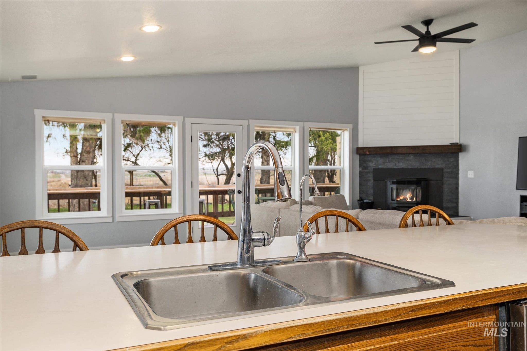 15032 Hollow Road Caldwell, ID 83607 - Photo 50 of 50 Kitchen featuring light countertops, a glass covered fireplace, lofted ceiling, ceiling fan, and open floor plan