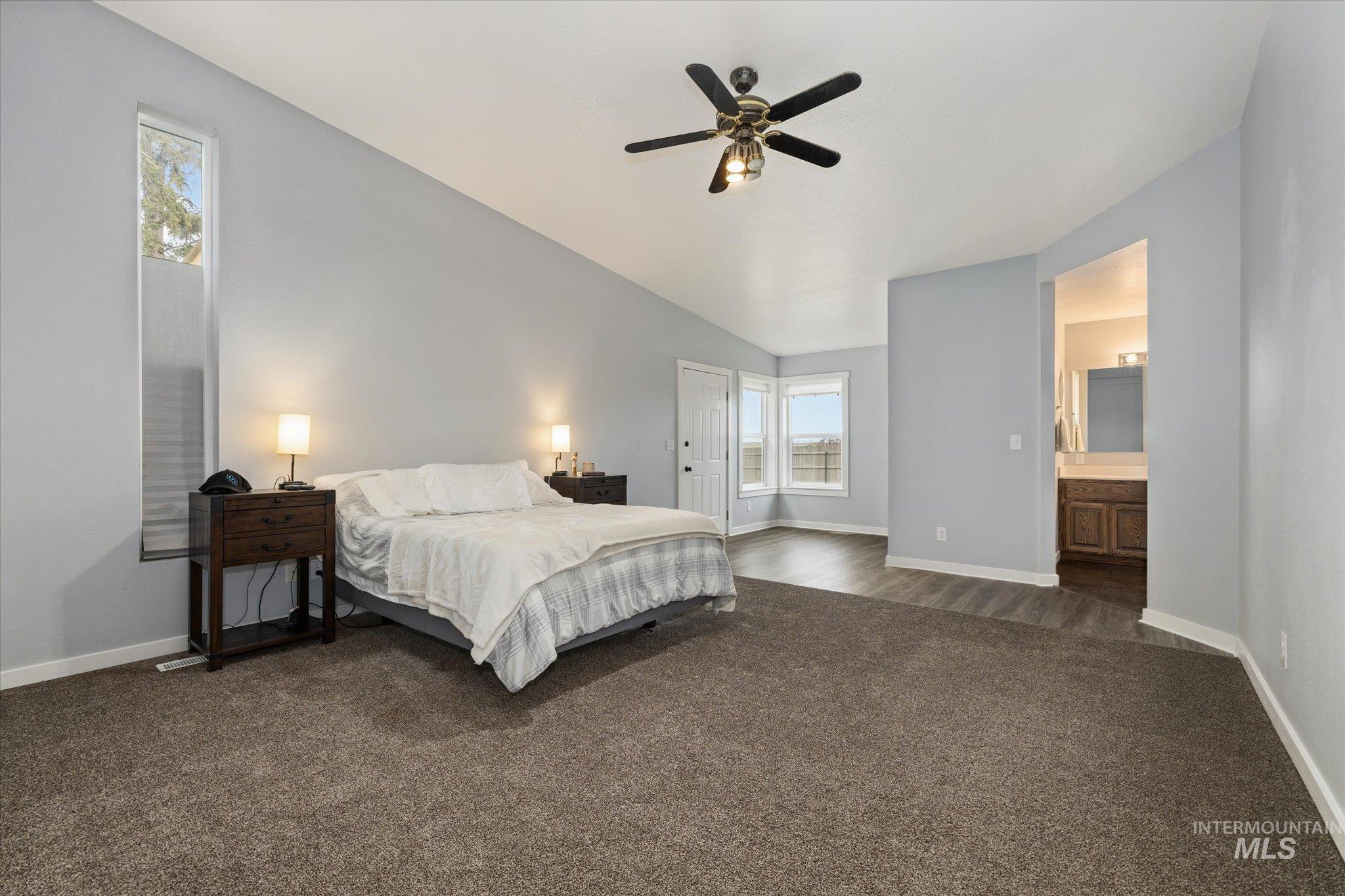 15032 Hollow Road Caldwell, ID 83607 - Photo 26 of 50 Bedroom featuring dark carpet, ceiling fan, and ensuite bathroom