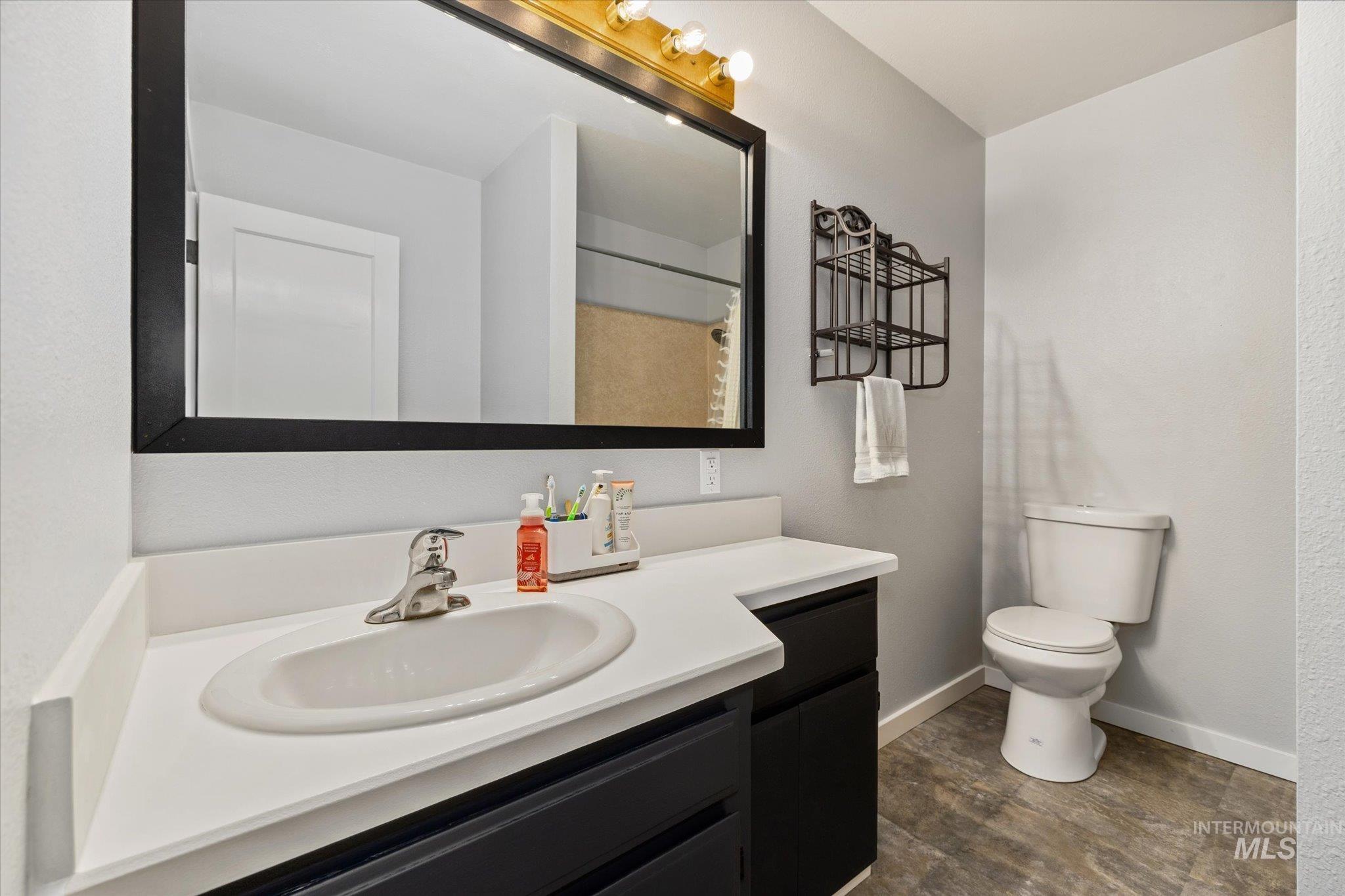15032 Hollow Road Caldwell, ID 83607 - Photo 31 of 50 Bathroom featuring vanity, a shower with curtain, and dark wood finished floors