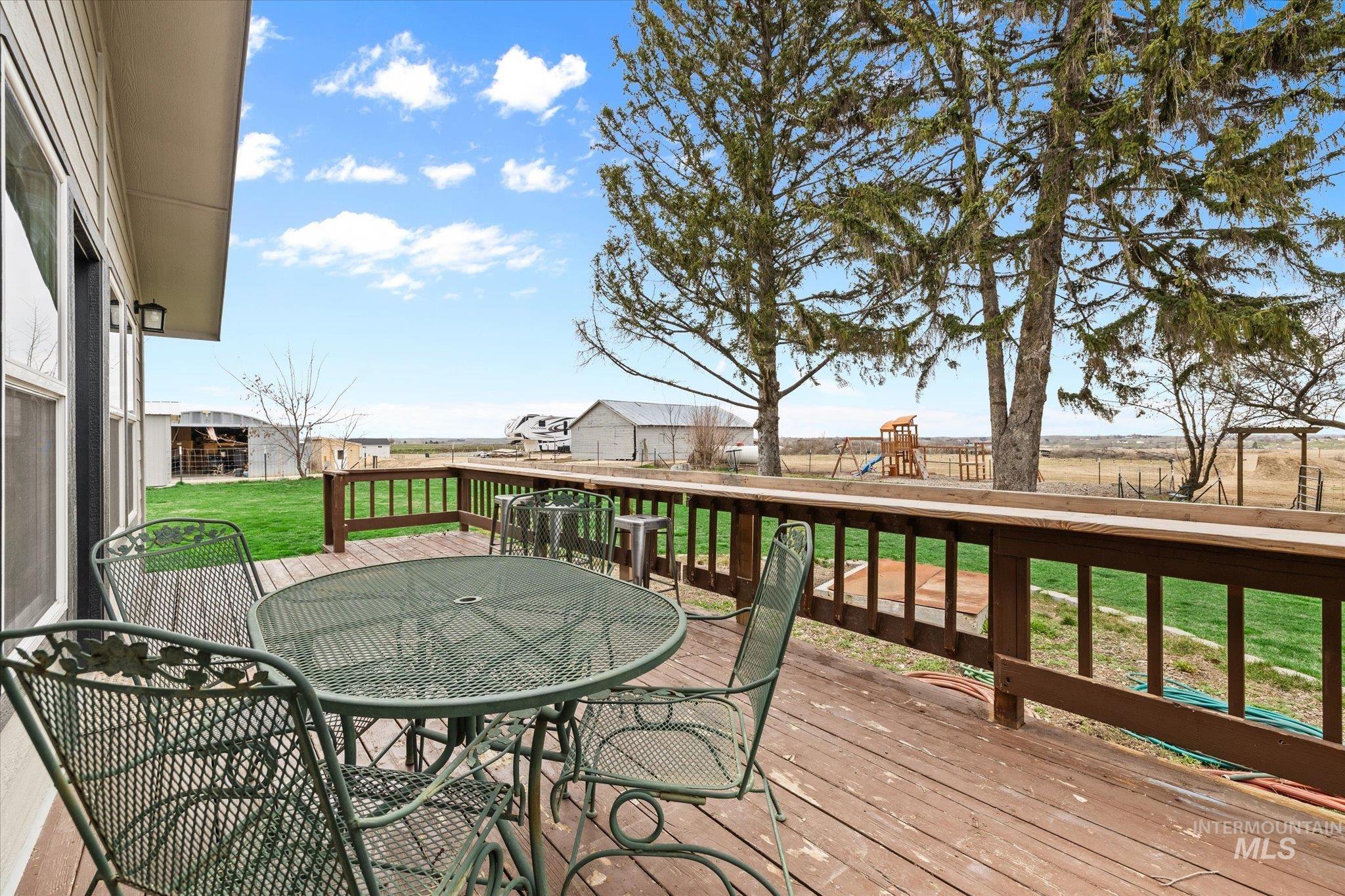 15032 Hollow Road Caldwell, ID 83607 - Photo 45 of 50 Wooden terrace featuring outdoor dining space, a playground, and a lawn