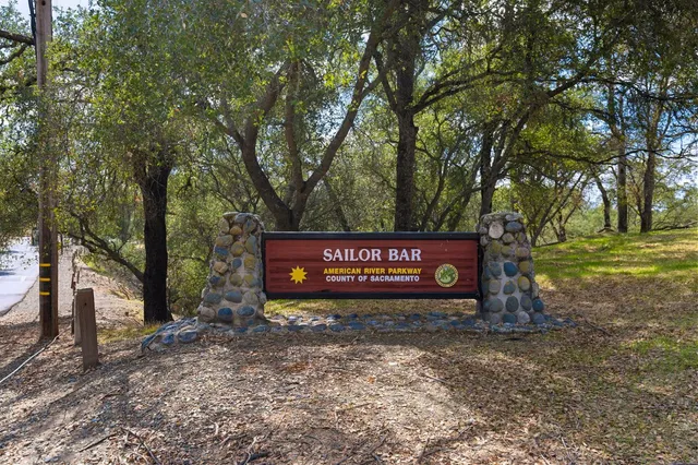 a sign board with tall trees