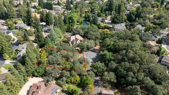 an aerial view of residential house with outdoor space and trees