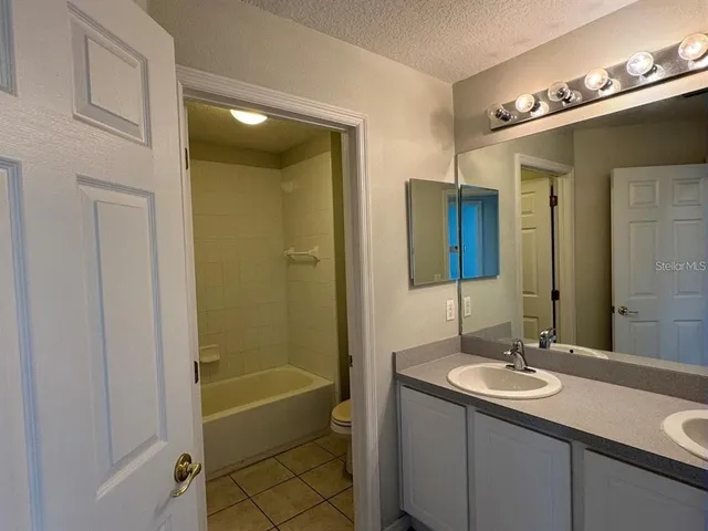 a bathroom with a granite countertop sink shower and a mirror