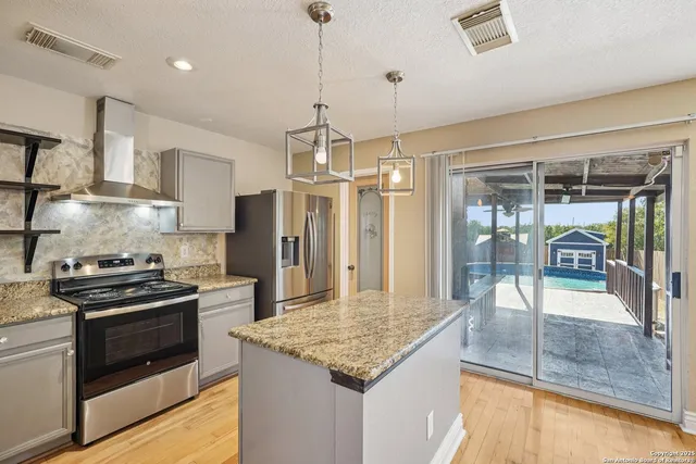 a kitchen with stainless steel appliances granite countertop a stove and a refrigerator
