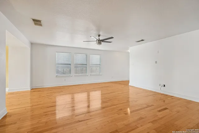a view of a room with wooden floor and fan