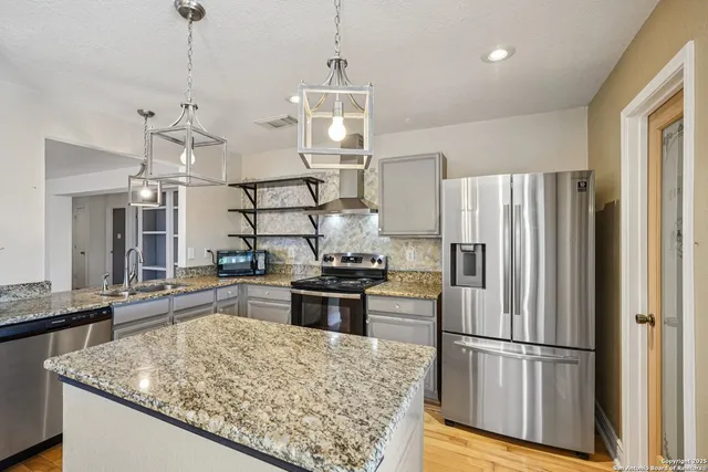 a kitchen with kitchen island a counter top space stainless steel appliances and cabinets