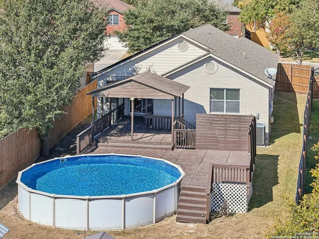 a view of a white house with a sink and wooden fence