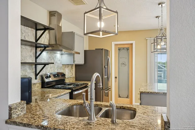 a kitchen with stainless steel appliances granite countertop a sink stove and refrigerator
