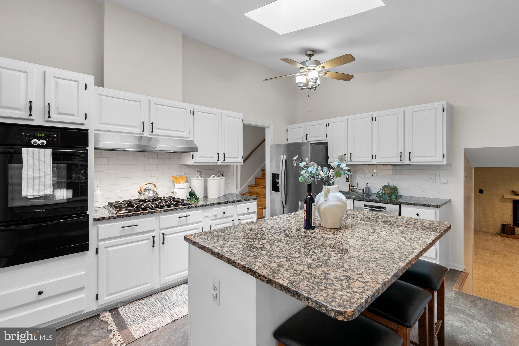 200 Eldrid Drive Silver Spring, MD 20904 - Photo 11 of 44 a kitchen with kitchen island granite countertop a table chairs stove and cabinets