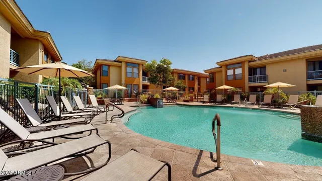 a view of a patio with table and chairs under an umbrella