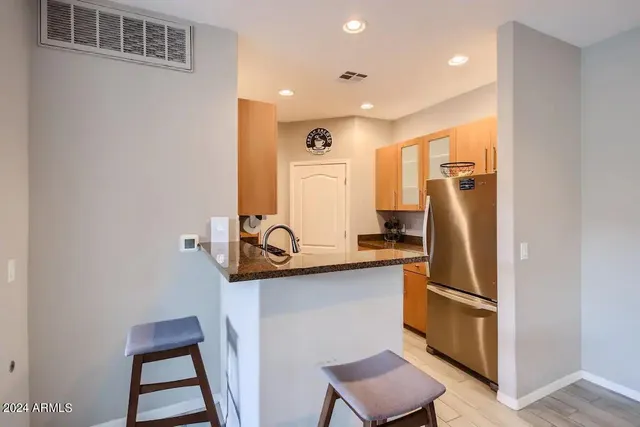 a kitchen with stainless steel appliances granite countertop a refrigerator and a sink