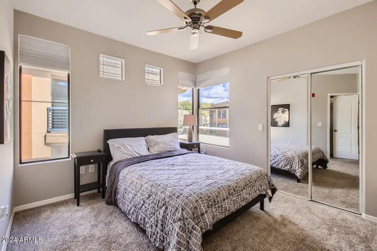 6900 East Princess Drive, Unit 2111 Phoenix, AZ 85054 - Photo 8 of 18 a bedroom with a bed and a chandelier
