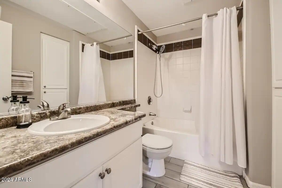 6900 East Princess Drive, Unit 2111 Phoenix, AZ 85054 - Photo 10 of 18 a bathroom with a granite countertop sink toilet and shower