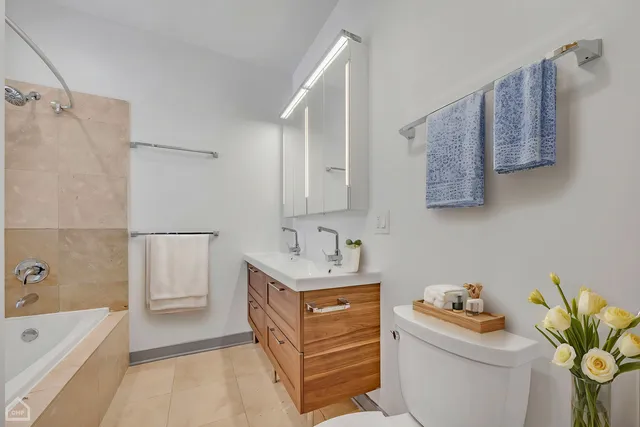 a bathroom with a toilet sink double vanity and mirror