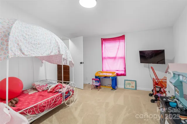 a bedroom with furniture and a flat screen tv