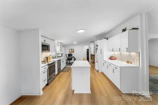 a kitchen with cabinets and wooden floor