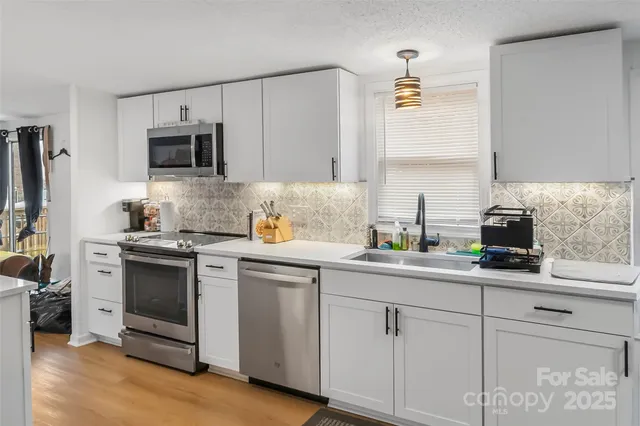 a kitchen with white cabinets and white appliances