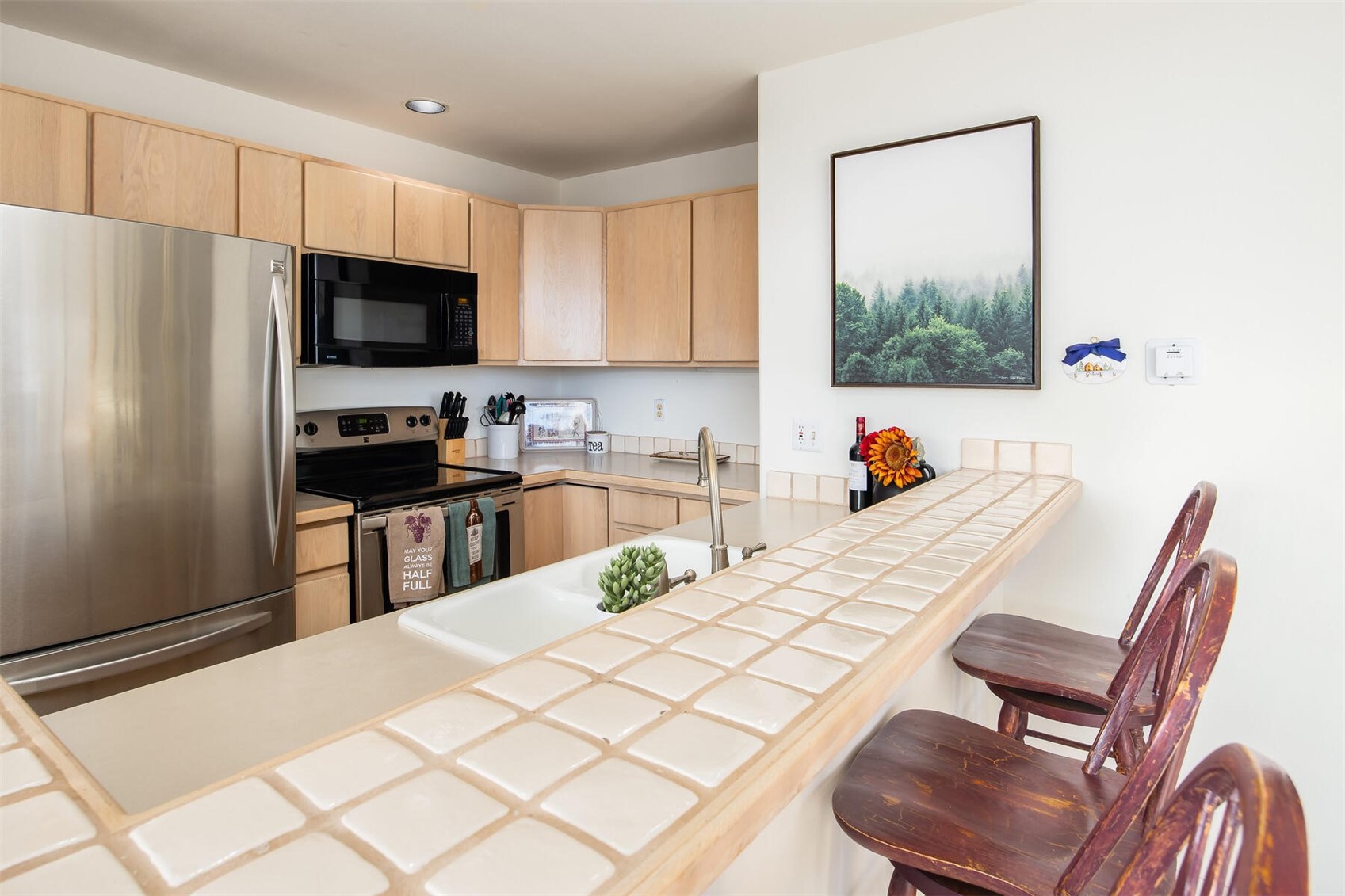 95600 Ryan Gulch Road, Unit 631 Silverthorne, CO 80498 - Photo 14 of 44 a kitchen with stainless steel appliances a stove a refrigerator a sink a dining table and chairs