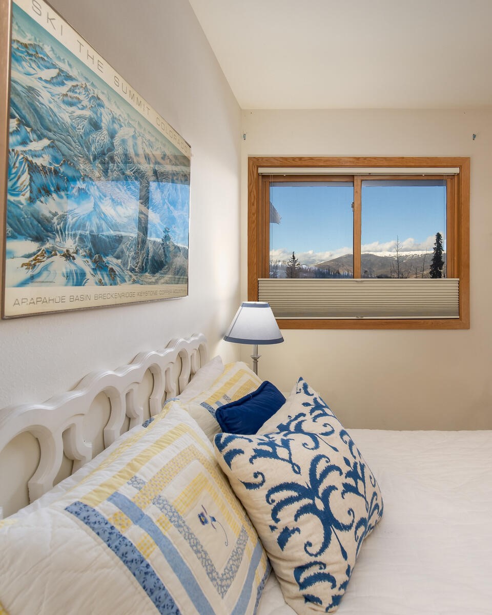 95600 Ryan Gulch Road, Unit 631 Silverthorne, CO 80498 - Photo 22 of 44 a bedroom with a bed and a painting on the wall