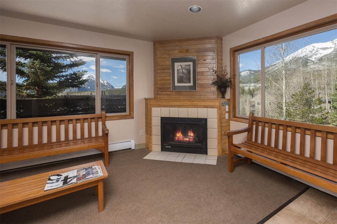 95600 Ryan Gulch Road, Unit 631 Silverthorne, CO 80498 - Photo 37 of 44 a living room with furniture a fireplace and a floor to ceiling window