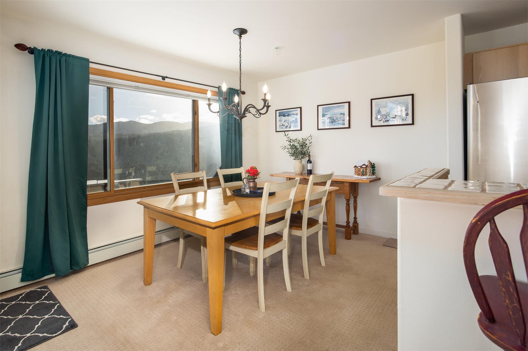95600 Ryan Gulch Road, Unit 631 Silverthorne, CO 80498 - Photo 9 of 44 a dining room with furniture a chandelier and window