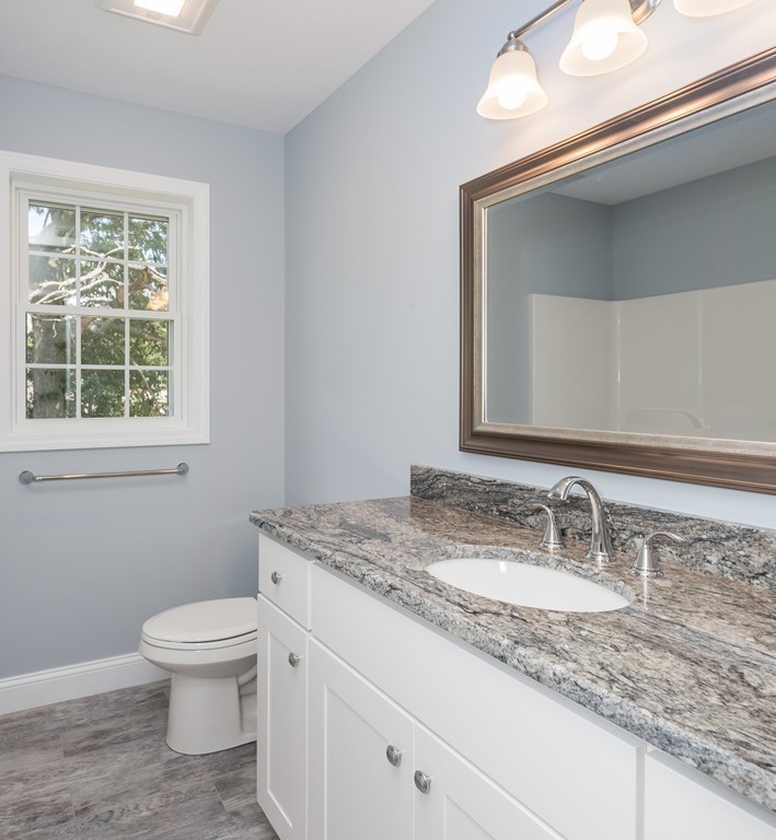 89 Wallace Street Springfield, MA 01119 - Photo 23 of 28 a bathroom with a granite countertop toilet a sink and a mirror