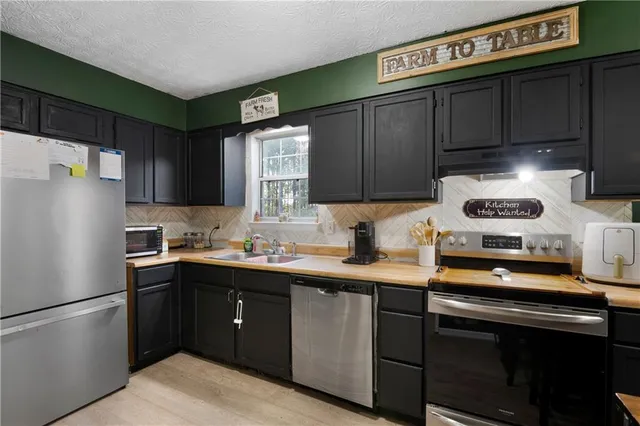 a kitchen with stainless steel appliances granite countertop a refrigerator stove a sink and dishwasher