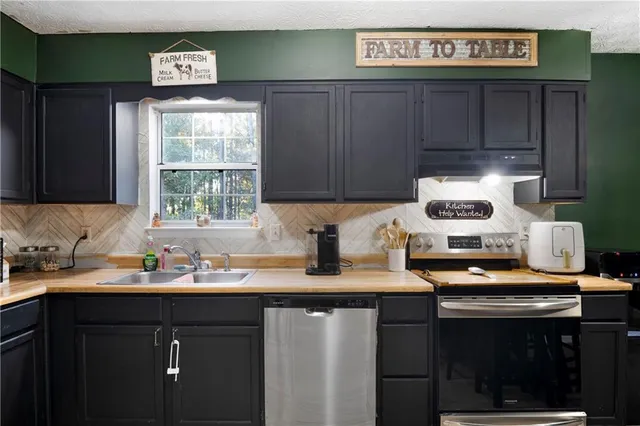a kitchen with stainless steel appliances granite countertop a sink stove and cabinets