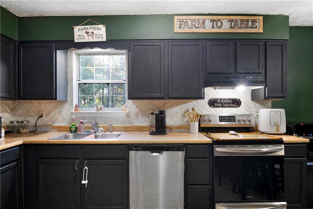 988 Davenport Road Southwest Dalton, GA 30721 - Photo 13 of 29 a kitchen with stainless steel appliances granite countertop a sink stove and cabinets