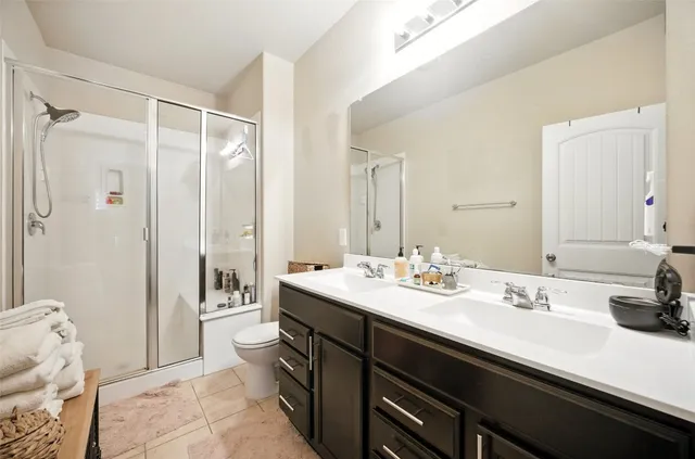 a bathroom with a sink a toilet and shower