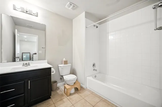 a bathroom with a bathtub shower sink mirror vanity and toilet