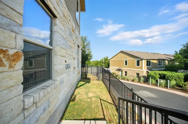 a view of a brick house with a small yard