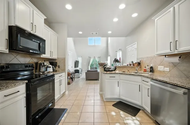 a kitchen with stainless steel appliances granite countertop a sink and stove top oven