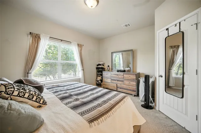 a bedroom with a bed and a large mirror