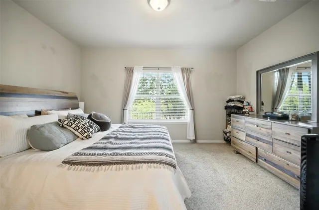 a bedroom with a bed and a large window