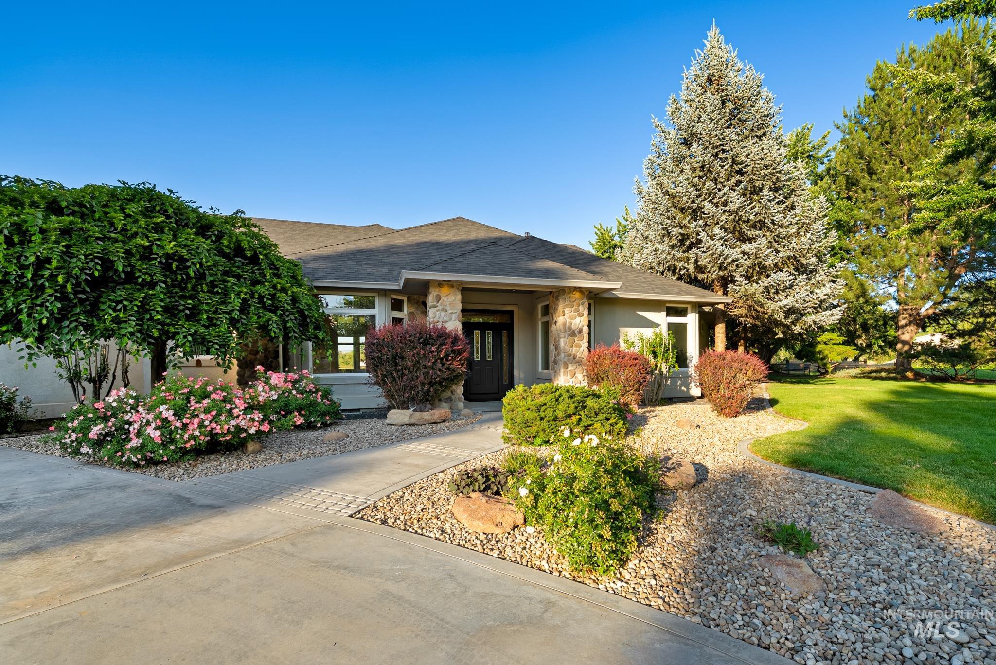 2050 Artesian Road Eagle, ID 83616 - Photo 3 of 49 Ranch-style exterior with stone accents, a multi-pane front door, and a spacious front lawn