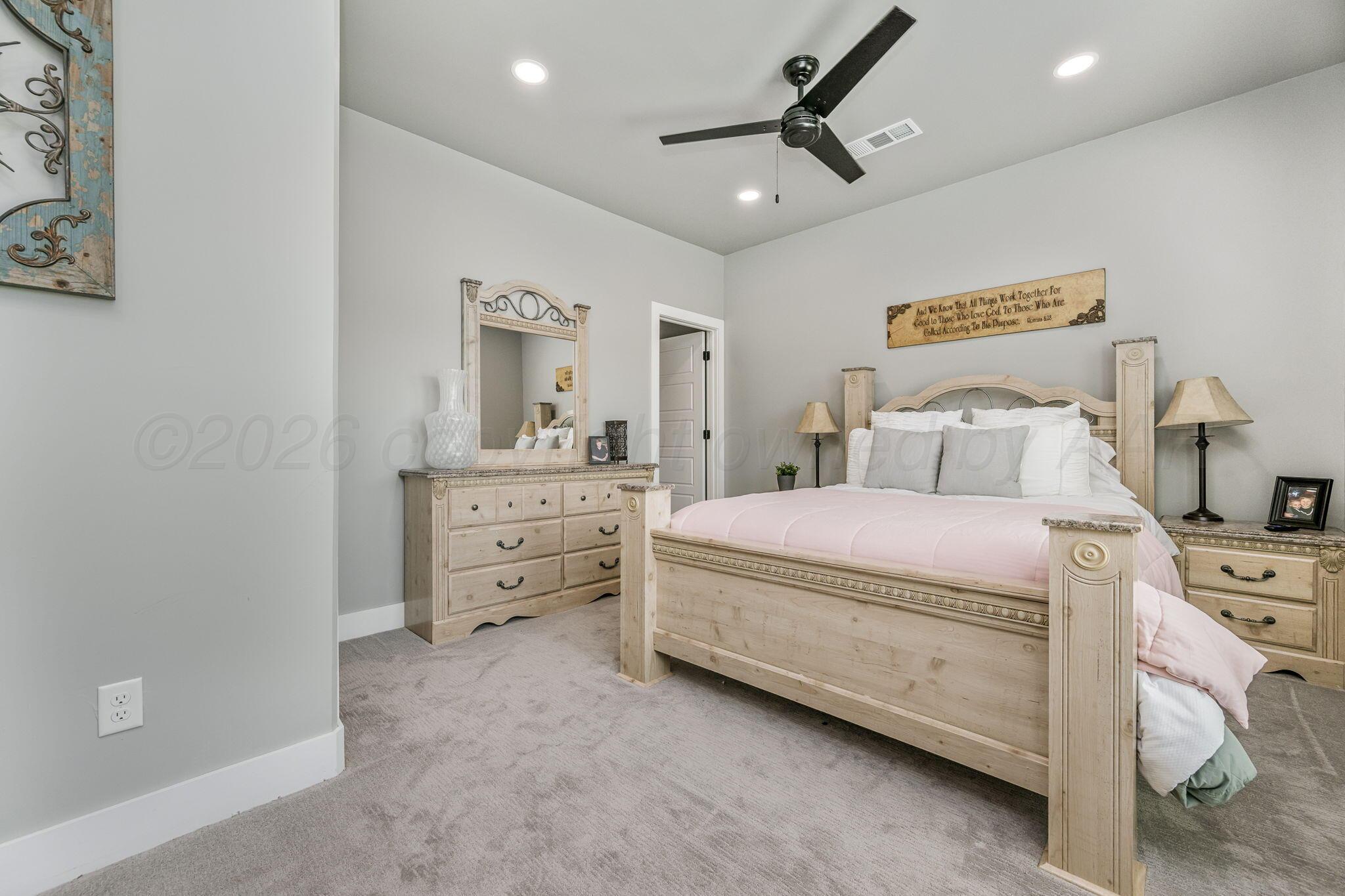17400 Spring Lake Drive Canyon, TX 79015 - Photo 22 of 52 a bedroom with a bed and a chandelier