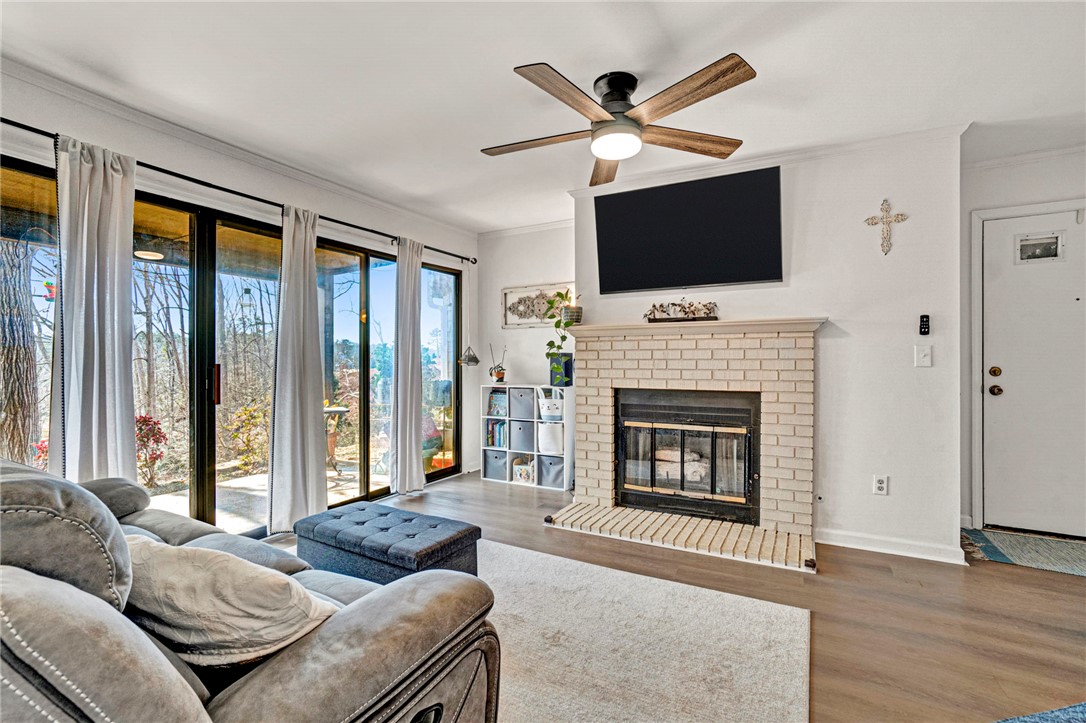 104 Captains Way Anderson, SC 29625 - Photo 5 of 47 This inviting living space features expansive glass doors, a cozy fireplace, and rich wood flooring.