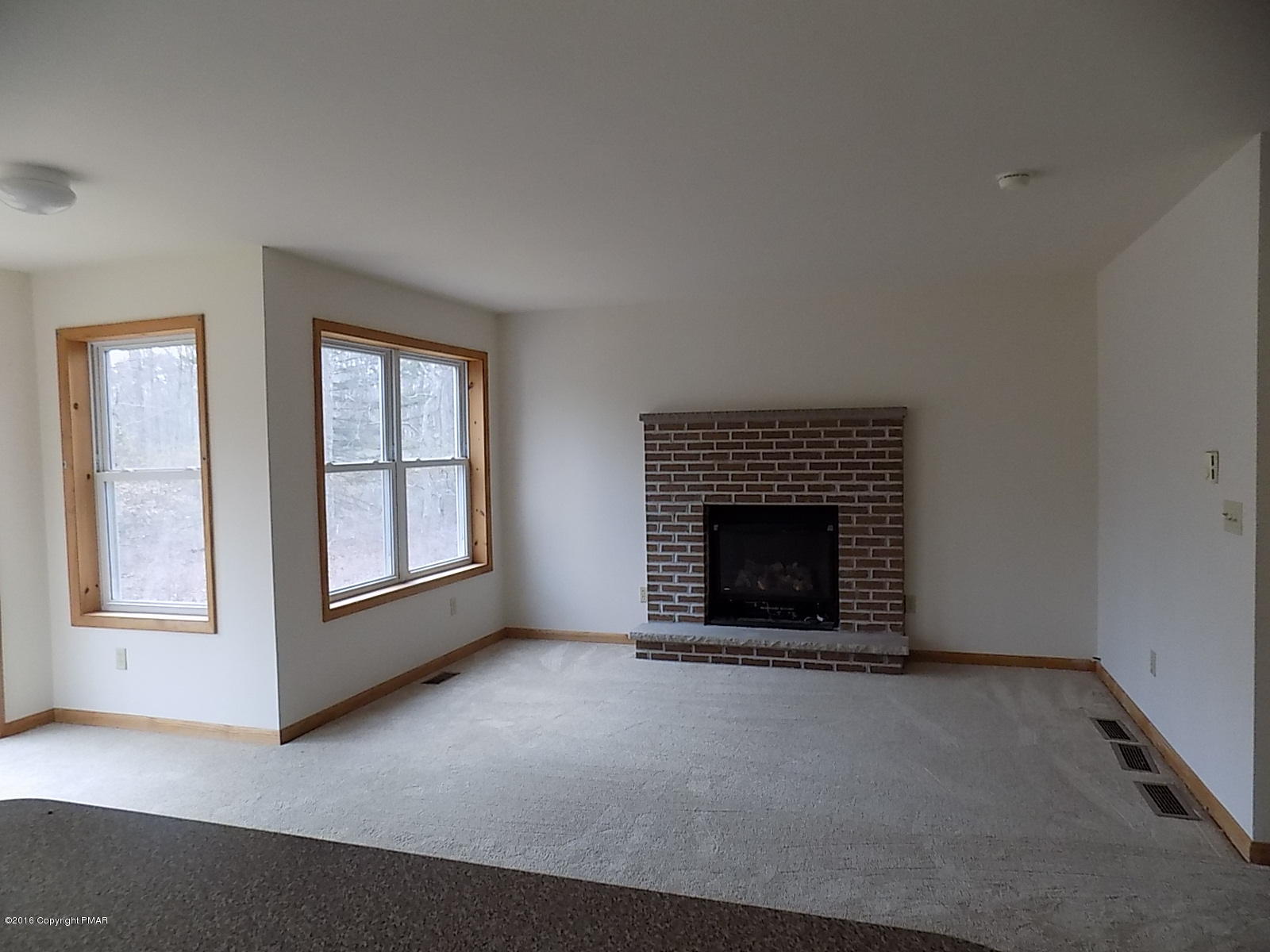 266 Oneida Way Milford, PA 18337 - Photo 11 of 22 an empty room with a fireplace and window