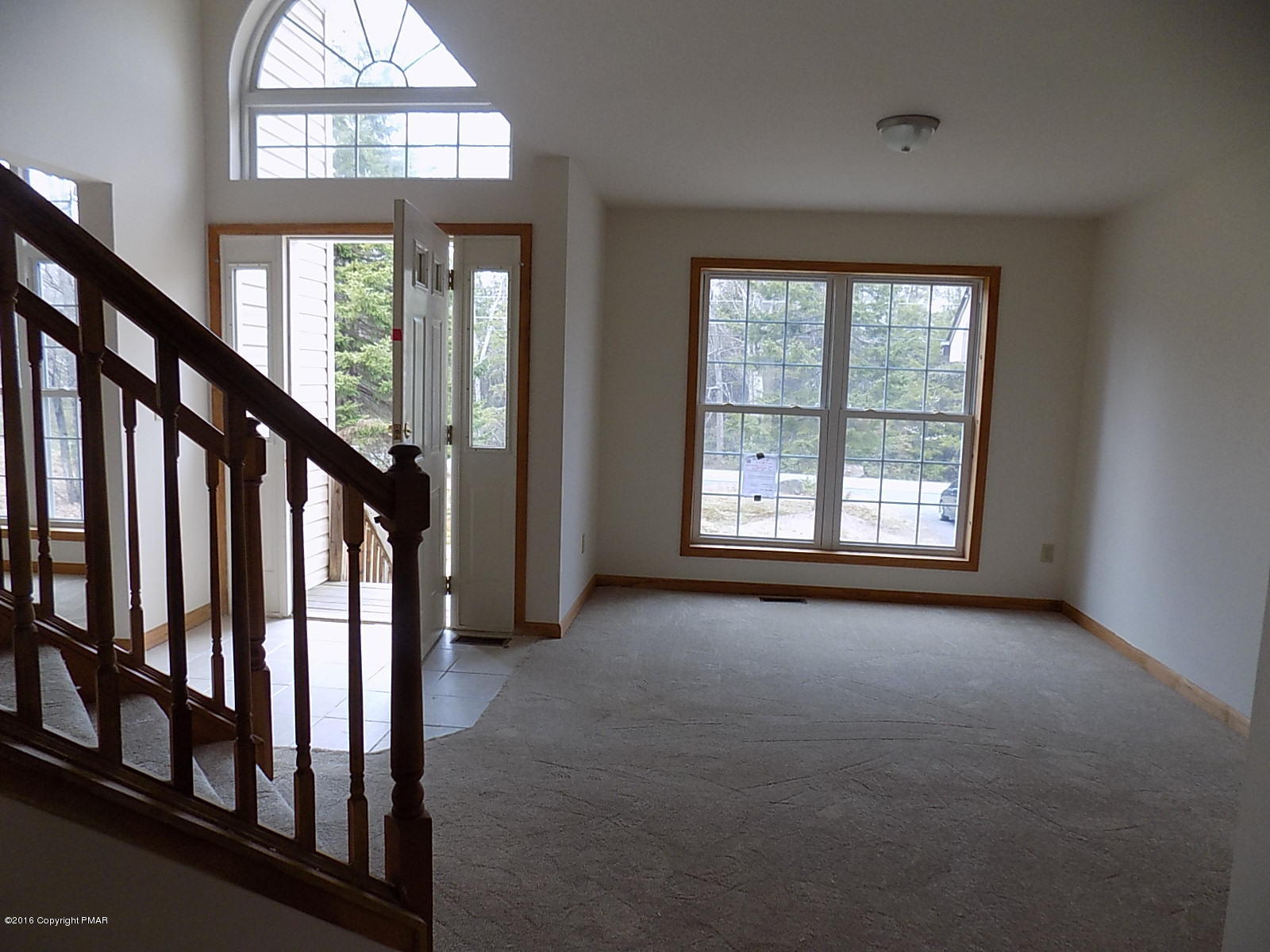 266 Oneida Way Milford, PA 18337 - Photo 8 of 22 an empty room with wooden floor windows and stairs