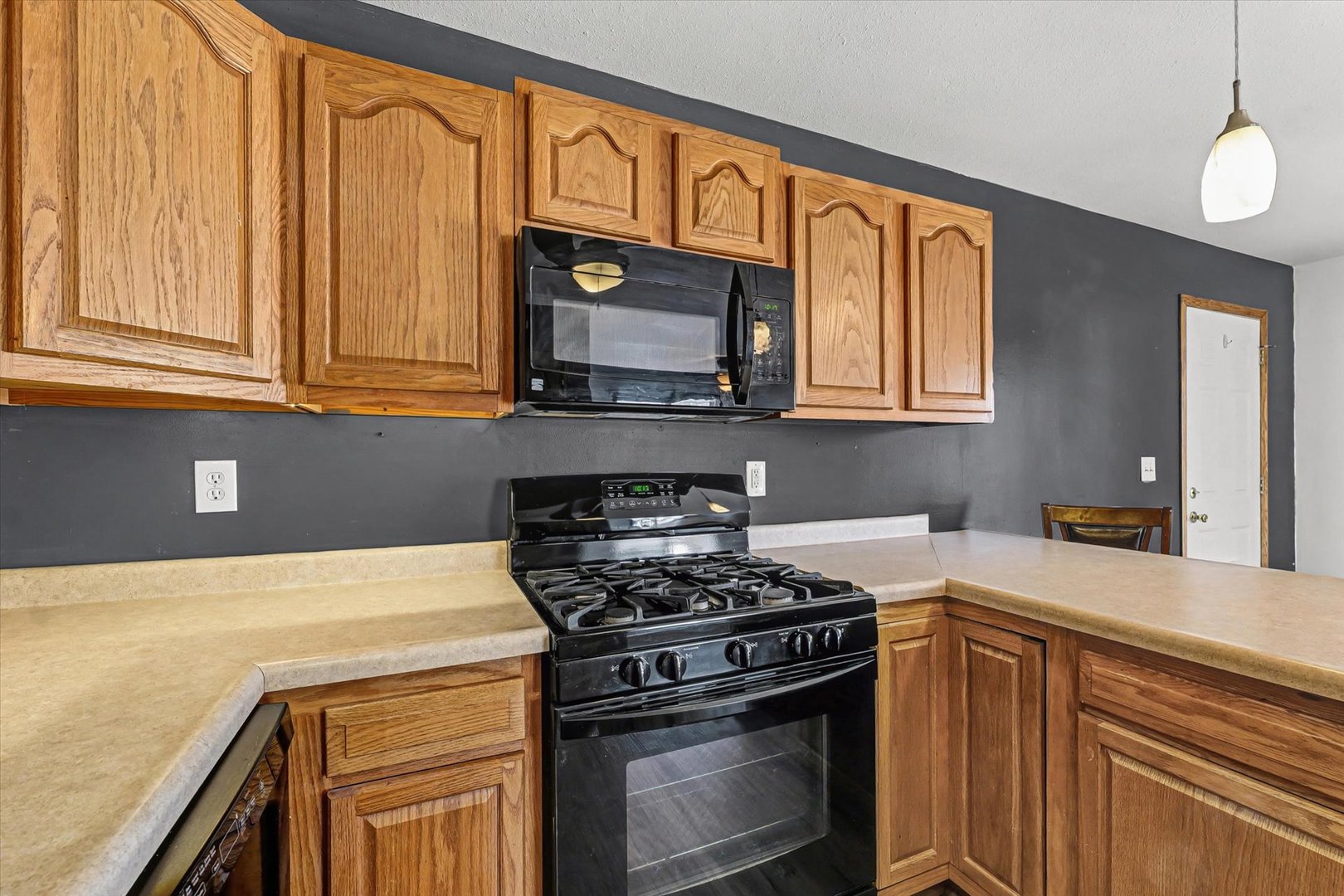 306 B W Lytle Street Newman, IL 61942 - Photo 13 of 47 a kitchen with stainless steel appliances granite countertop a stove a sink and a microwave