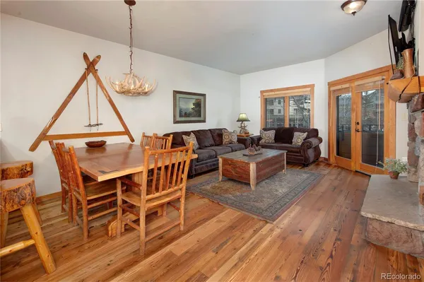 a living room with furniture a wooden floor and a floor to ceiling window