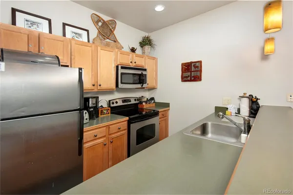 a kitchen with stainless steel appliances a refrigerator sink and stove