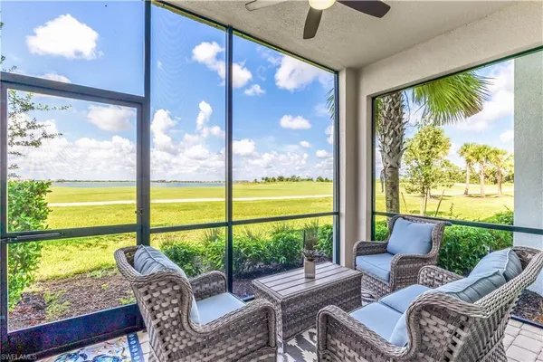 a living room with patio furniture and garden view
