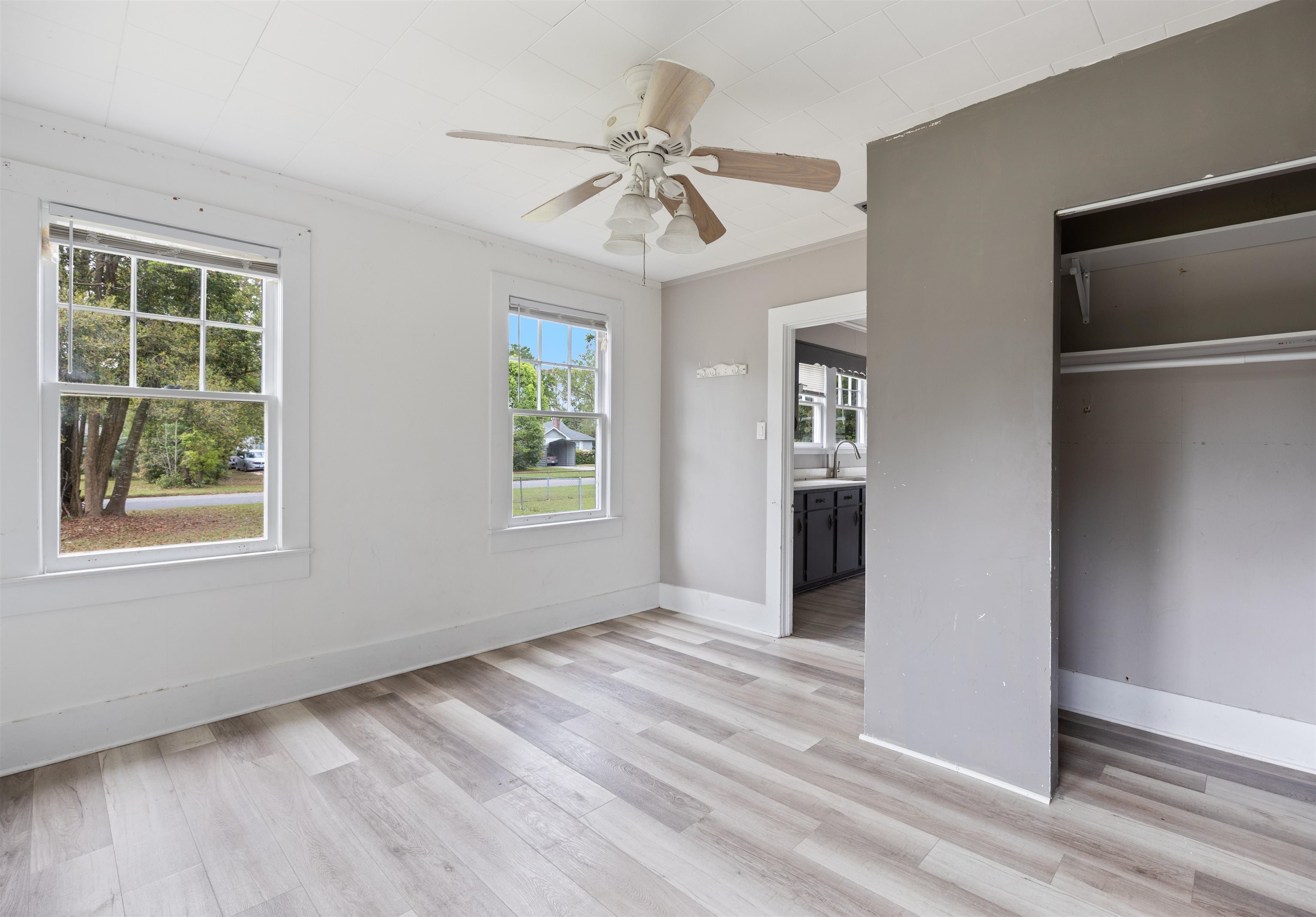 112 South Juniper Street Foley, AL 36535 - Photo 33 of 64 Unfurnished bedroom with light wood finished floors, a ceiling fan, ornamental molding, and a closet